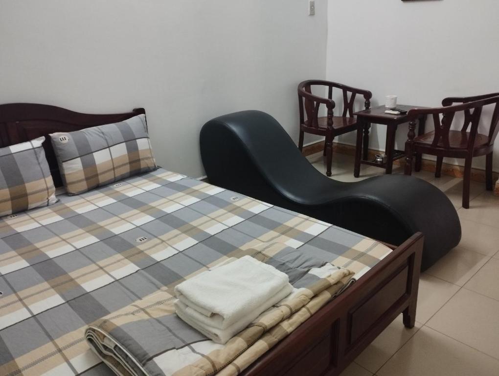 胡志明市Sứ Lạng Hotel的一间卧室配有一张黑色床头板的床