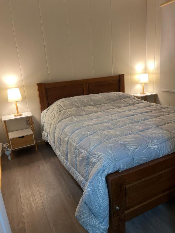 奇廉Pewma Apart Hotel的一间卧室配有一张带2个床头柜的大床