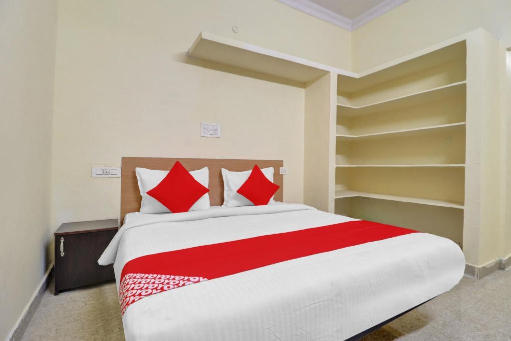 Haidar Sāhibgūda80983G RBS Square Langer Houz的一间卧室配有一张带红色枕头的大床