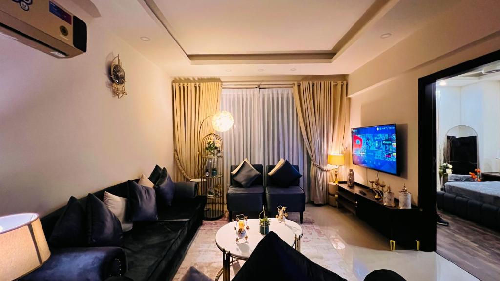 伊斯兰堡Executive One Bedroom Apartment Opposite Centaurus Mall Islamabad的客厅配有蓝色的沙发和电视