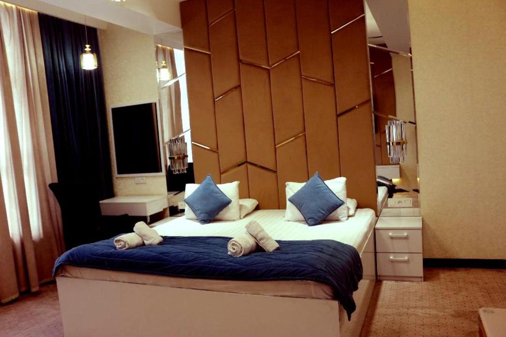 杜尚别Hotel Tajikgrey Dushanbe的一间卧室配有一张带蓝色枕头的大床