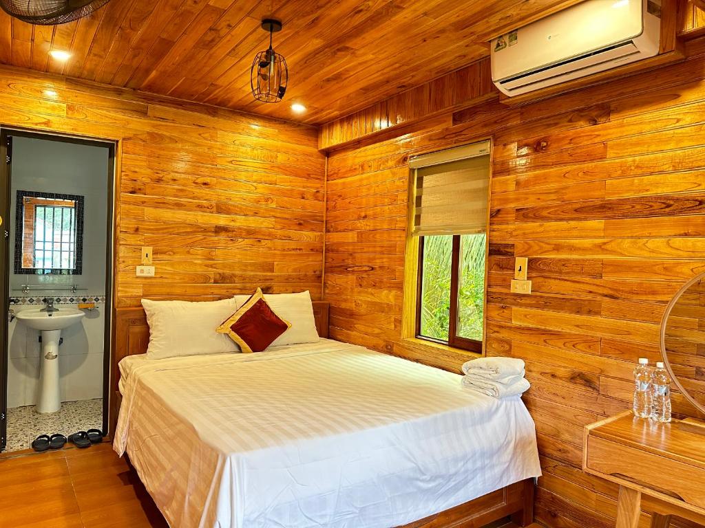 宁平Tam Coc Rocky Hotel的木制客房内的一间卧室,配有一张床
