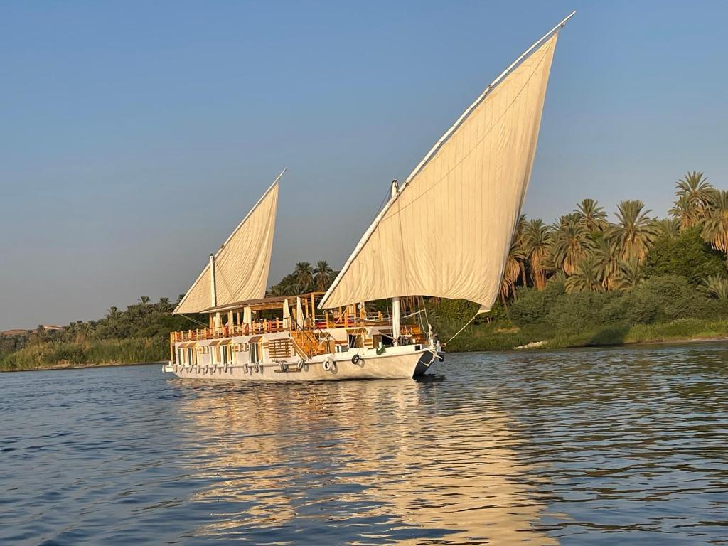 卢克索Dahabiya Nile Sailing-Every Monday 4 Nights from Luxor-Every Friday 3 Nights from Aswan的两帆在水面上的白色船