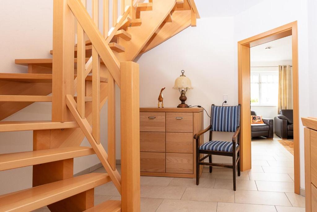 博尔库姆Ferienhaus Inselliebe的客厅的楼梯,配有椅子和书桌