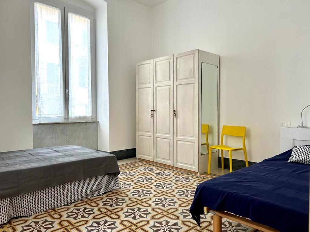 斯培西亚aCàToa - spacious bright apartment in the city center 3 bedrooms - La Spezia / easy access and connections to 5 Terre and Portovenere的一间卧室配有一张床、一个橱柜和椅子