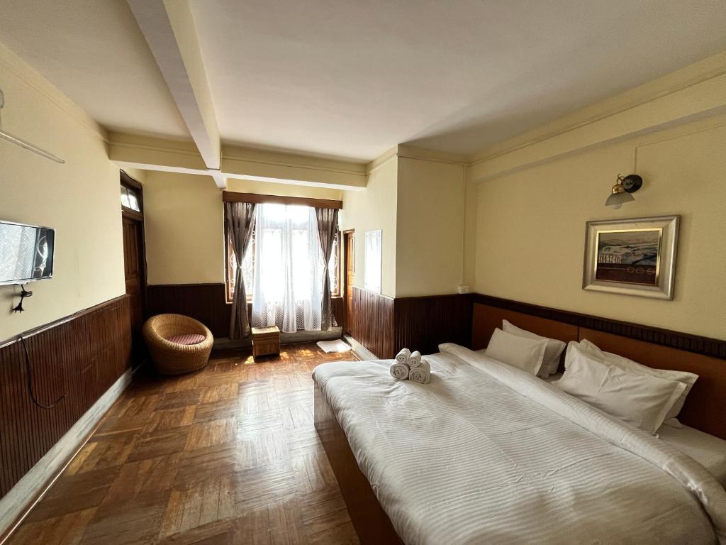 甘托克Yesheyzz的一间卧室设有一张大床和一个窗户。