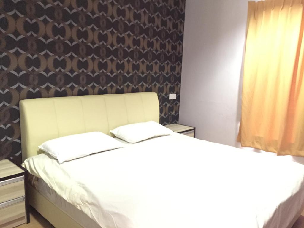 甘榜巴鲁泰斯樱花经济型酒店 的一间卧室设有两张床和一堵墙