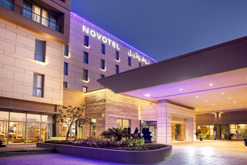 马斯喀特Novotel Muscat Airport的夜间在大楼前的酒店