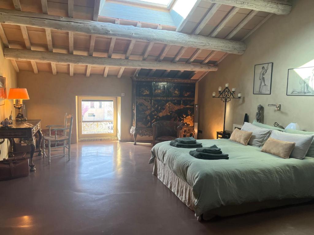 LapaludMaison en Provence的一间带一张大床的卧室,位于带桌子的房间