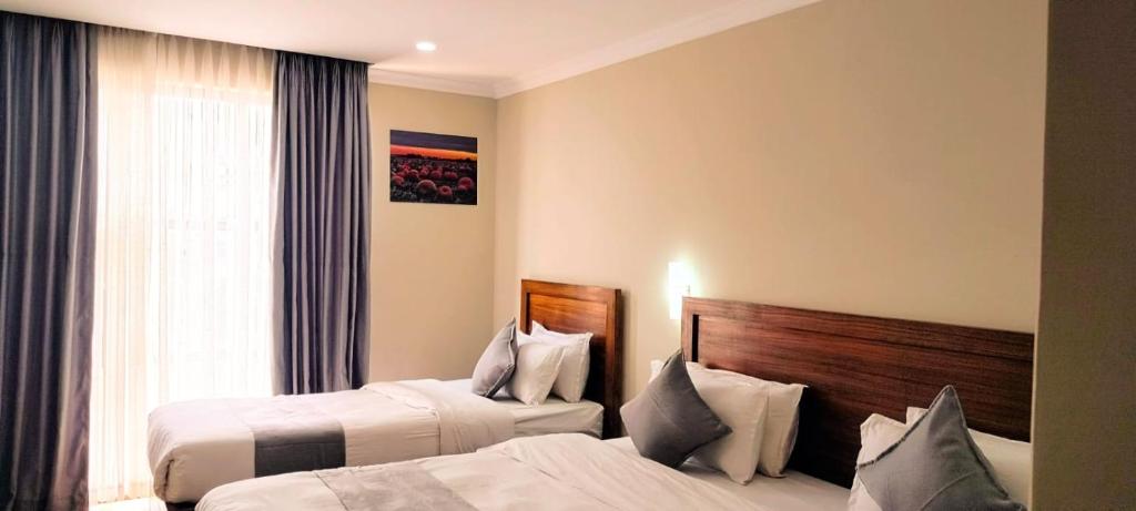 巴拉特布尔Hotel Gulmohar的酒店客房设有两张床和窗户。