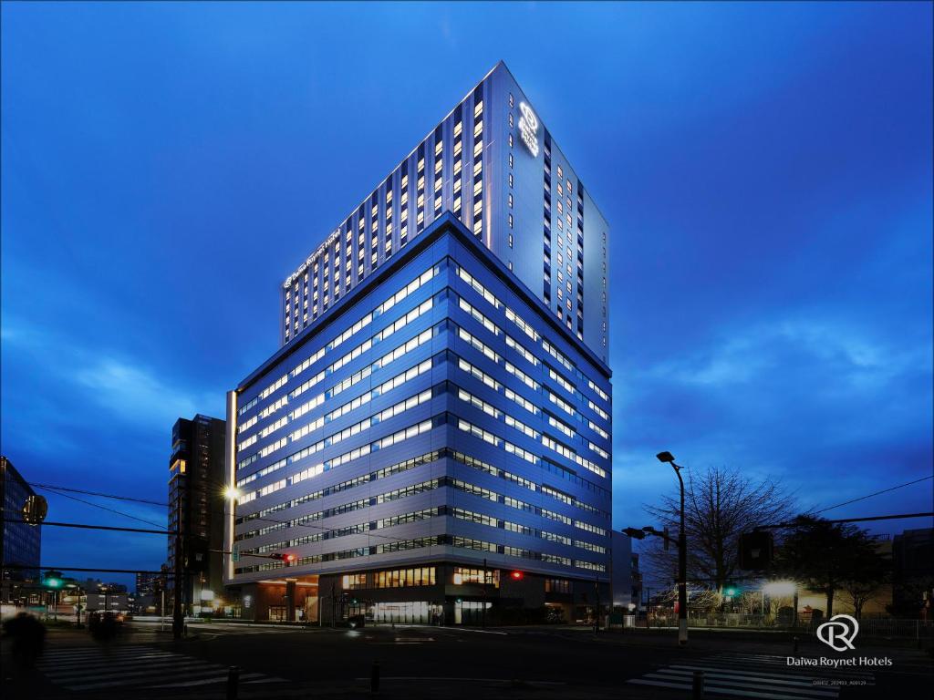埼玉市Daiwa Roynet Hotel Omiya-nishiguchi的一座高大的建筑,晚上有很多窗户