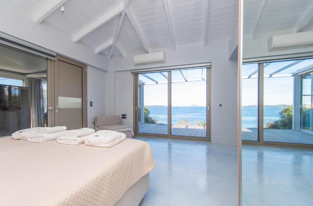 马蒂亚斯Beach Villa Cavo- with private sea access的白色卧室设有床和大窗户