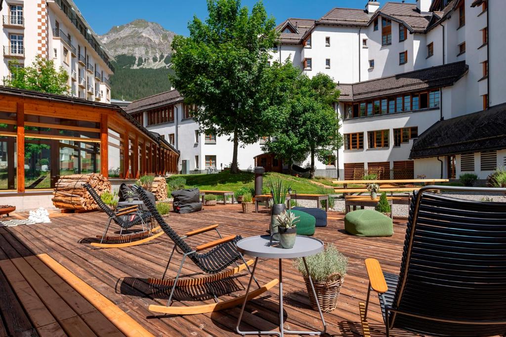 伦策海德斯维泽霍夫伦策海德酒店的一个带桌椅的庭院和山脉