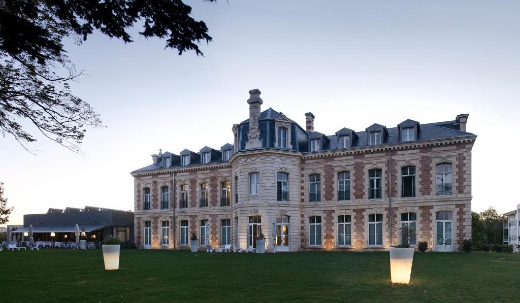 拉戈尔Hôtel et SPA du Château的前面有灯的大房子
