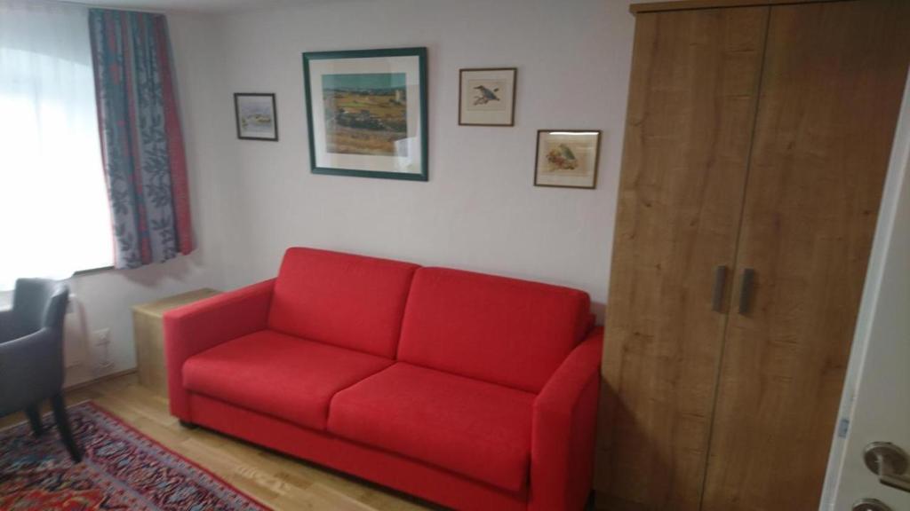 哈莱恩Appartement 2 Personen Hallein bei Salzburg的客厅里红色的沙发,有门