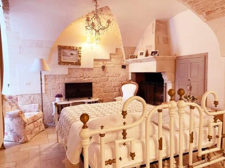 马丁纳弗兰卡La Neviera dell'Arco的卧室配有白色的床和壁炉