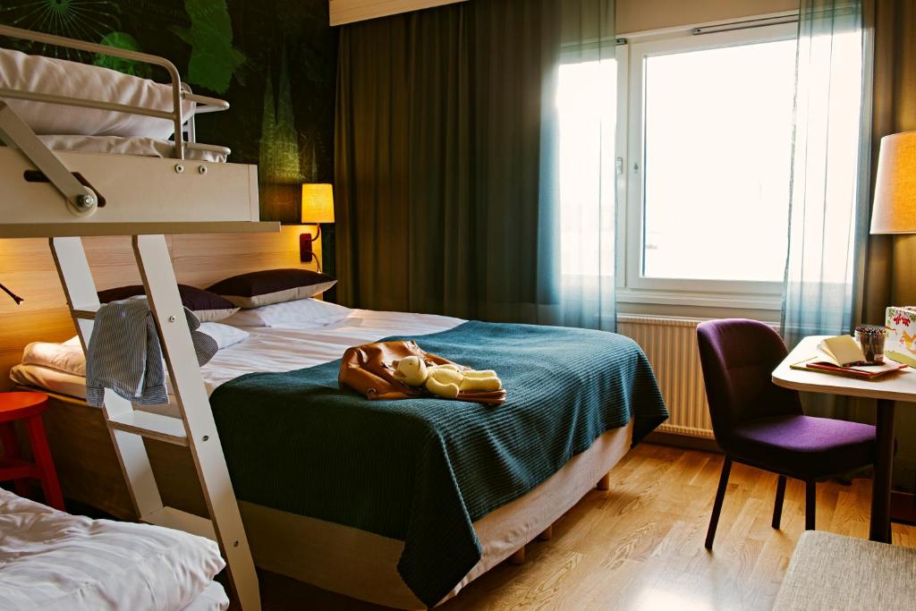 乌普萨拉斯堪迪克乌普萨拉诺德酒店的一间卧室配有两张双层床、一张桌子和一把椅子