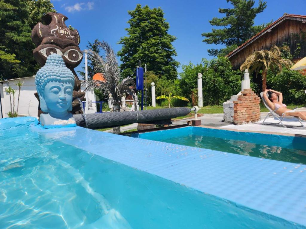 BrestovikSpa center Apartment Belgrad的坐在游泳池椅子上的女人,在水中雕像