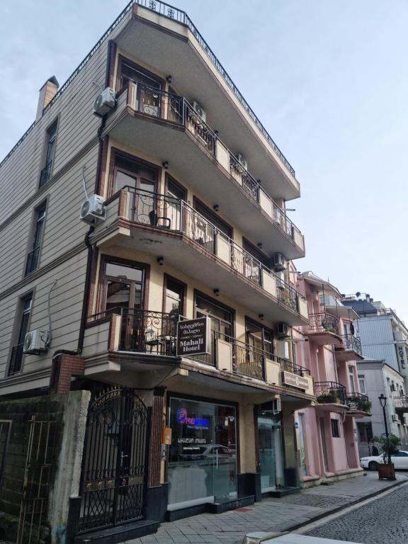 巴统MAHALI HOTEL的街道上带阳台的公寓大楼
