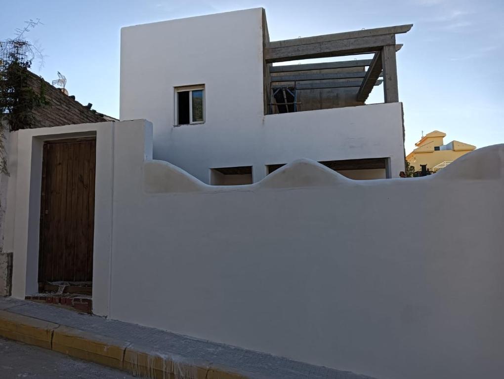 蓬塔翁布里亚Alhamar House with private pool的白色的房子,设有木门和围栏