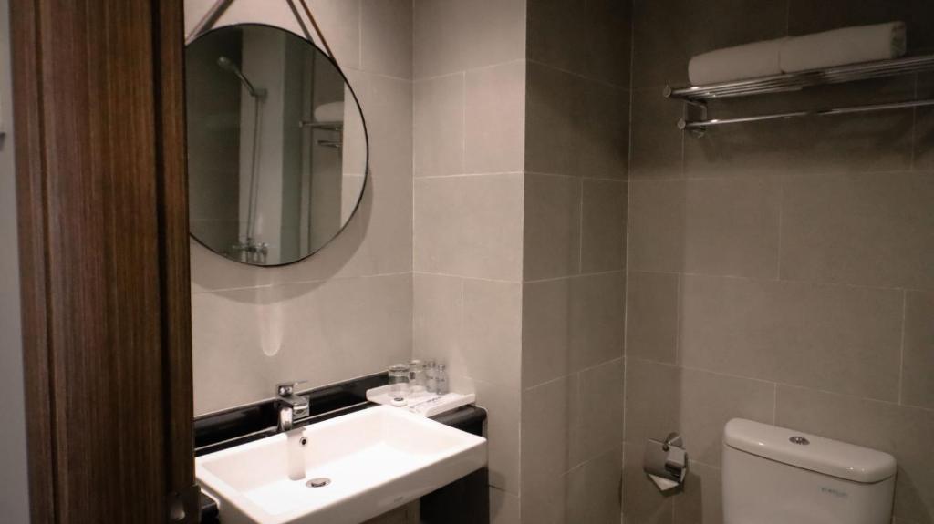 梭罗Solia Hotel Yosodipuro的一间带水槽、镜子和卫生间的浴室