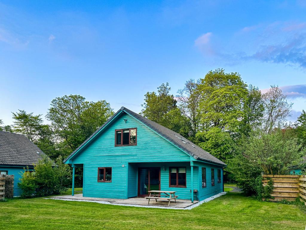 德里门Foxglove Cottages的庭院里带野餐桌的蓝色房子