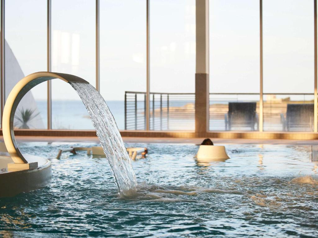 基伯龙Sofitel Quiberon Thalassa sea & spa的建筑物游泳池里的喷泉