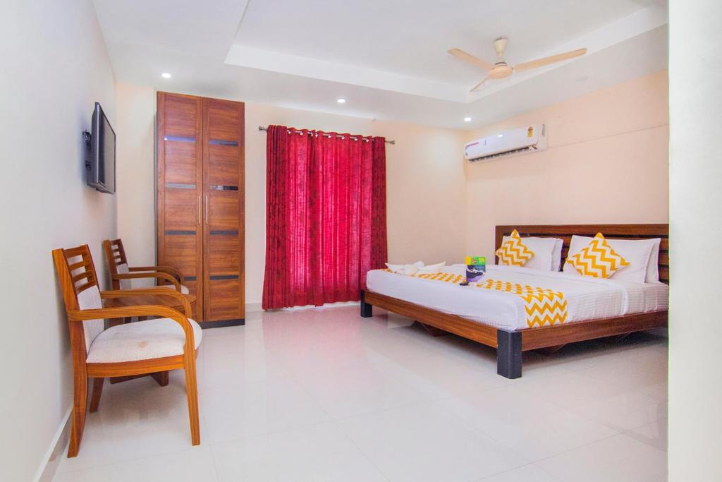 钦奈FabHotel Krishna Residency的一间卧室配有床和红色窗帘
