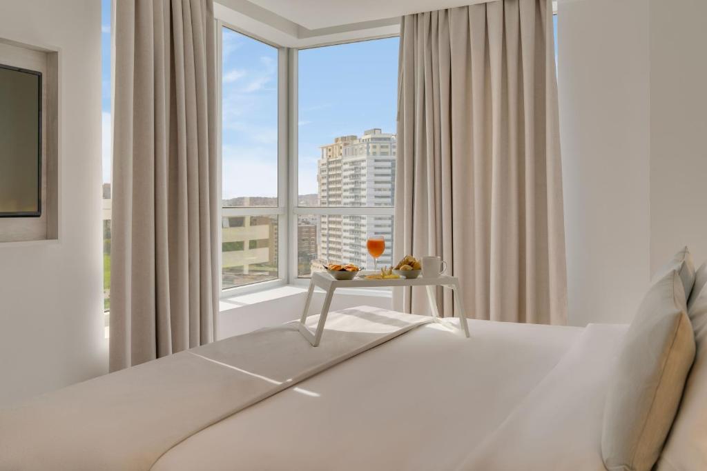 丹吉尔Pestana Tanger - City Center Hotel Suites & Apartments的一间卧室设有一张床和一个大窗户