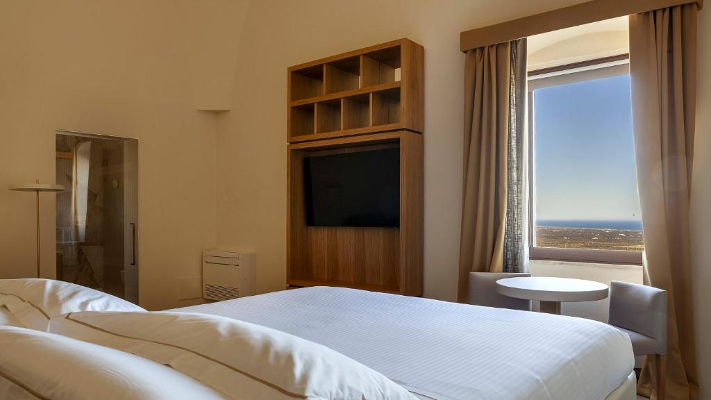 奥斯图尼松米塔城堡酒店的一间卧室设有一张床和一个大窗户
