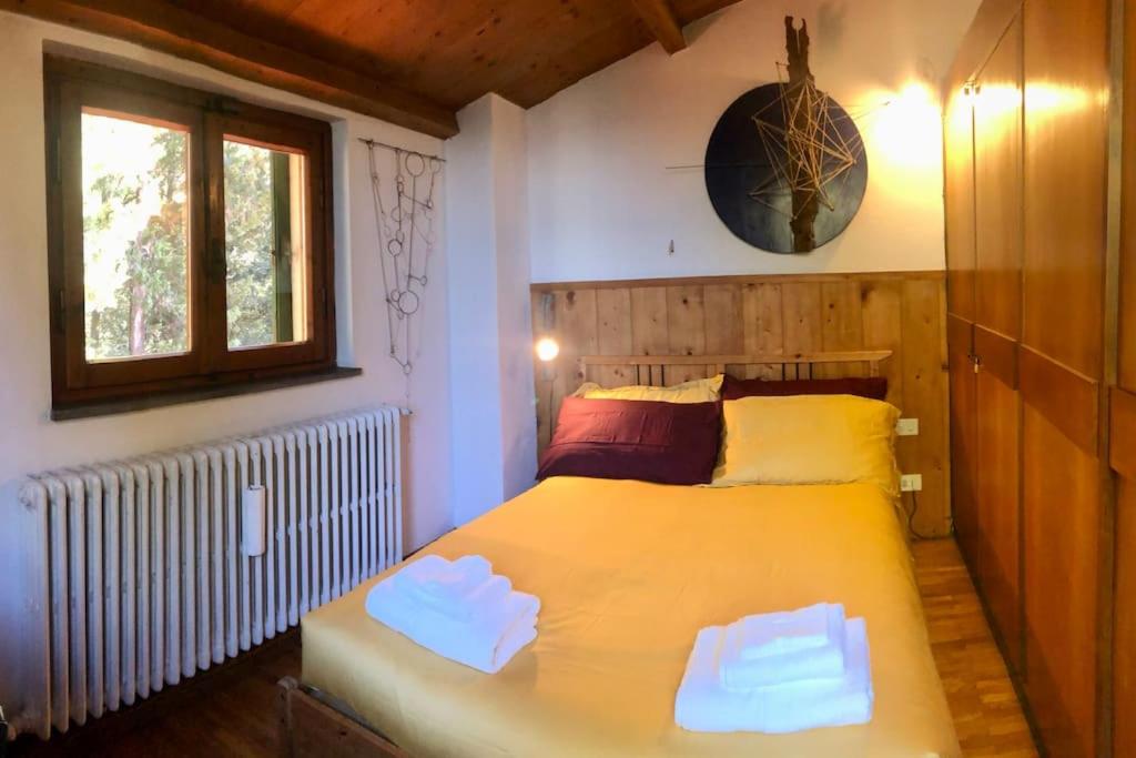 巴尼奥阿里波利La casa di Nello Bini con vista su Firenze的一间卧室设有一张大黄床和窗户