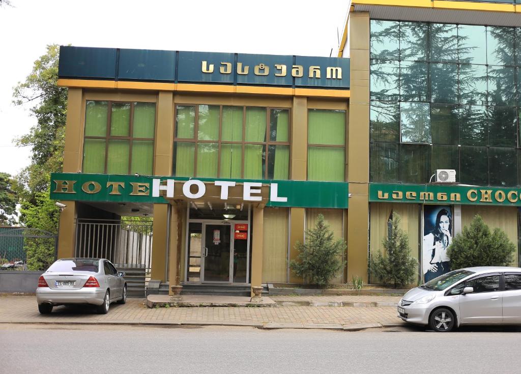 库塔伊西Georgian Paradise的前面有两辆车的酒店
