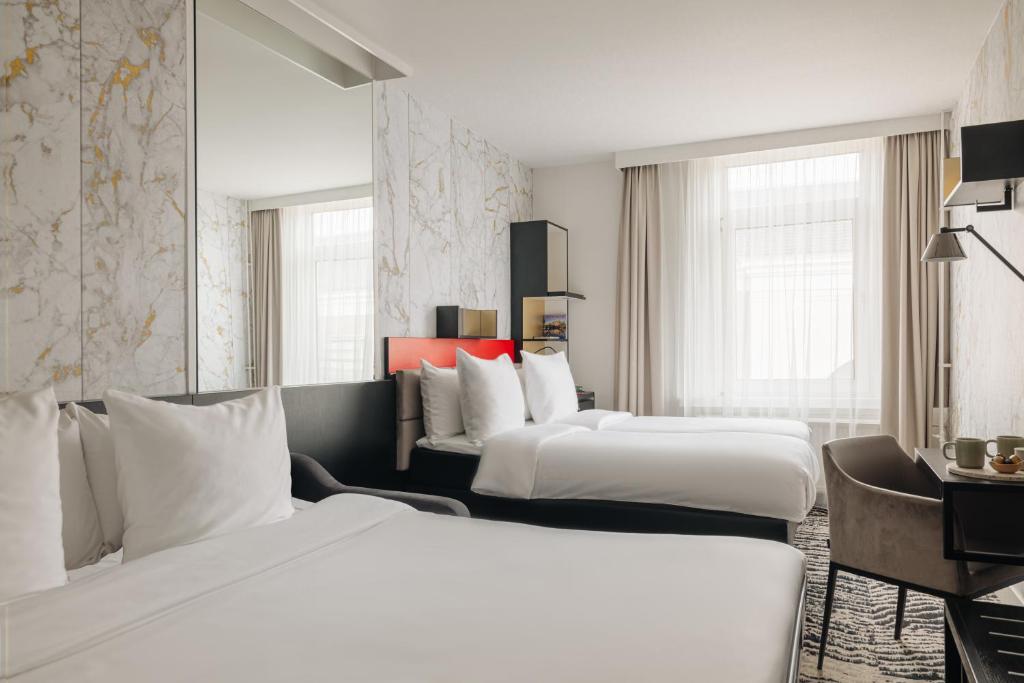 阿姆斯特丹阿姆斯特丹兰开斯特酒店的酒店客房配有两张床和一张书桌