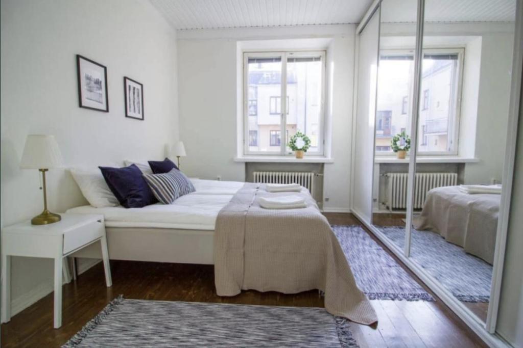 赫尔辛基2ndhomes Fabianinkatu Apartments的白色卧室配有床和镜子