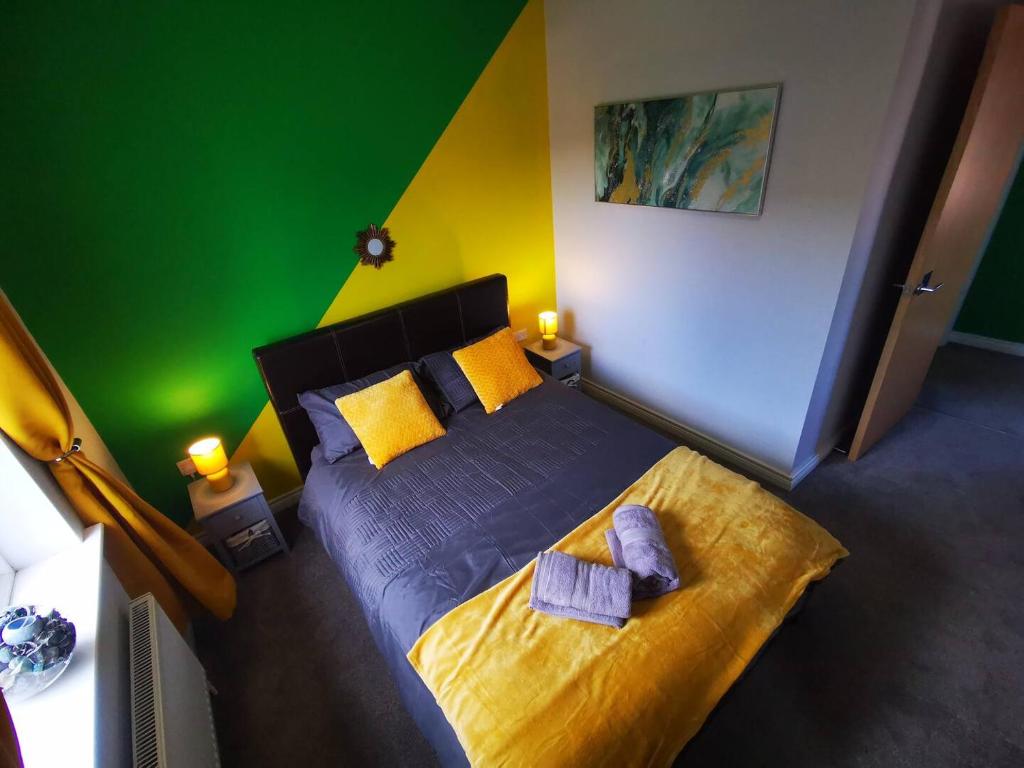 贝尔法斯特3br Cosy Modern Stay的一间卧室设有一张黄色和绿色墙壁的床。