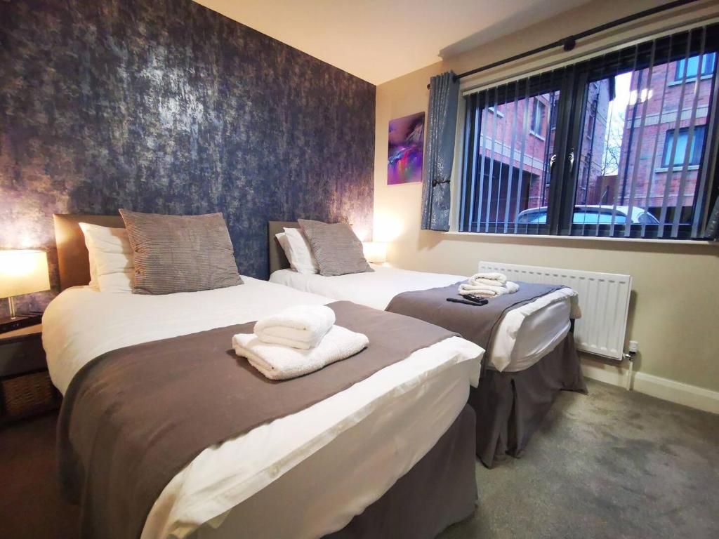 贝尔法斯特Belfast Central 2 Bedroom Luxurious Modern Stay的一间卧室设有两张床和窗户。