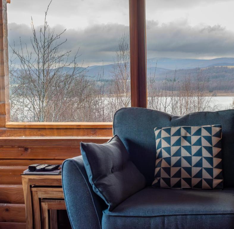 金克雷格因什湖小木屋有限公司酒店的窗前的蓝色沙发