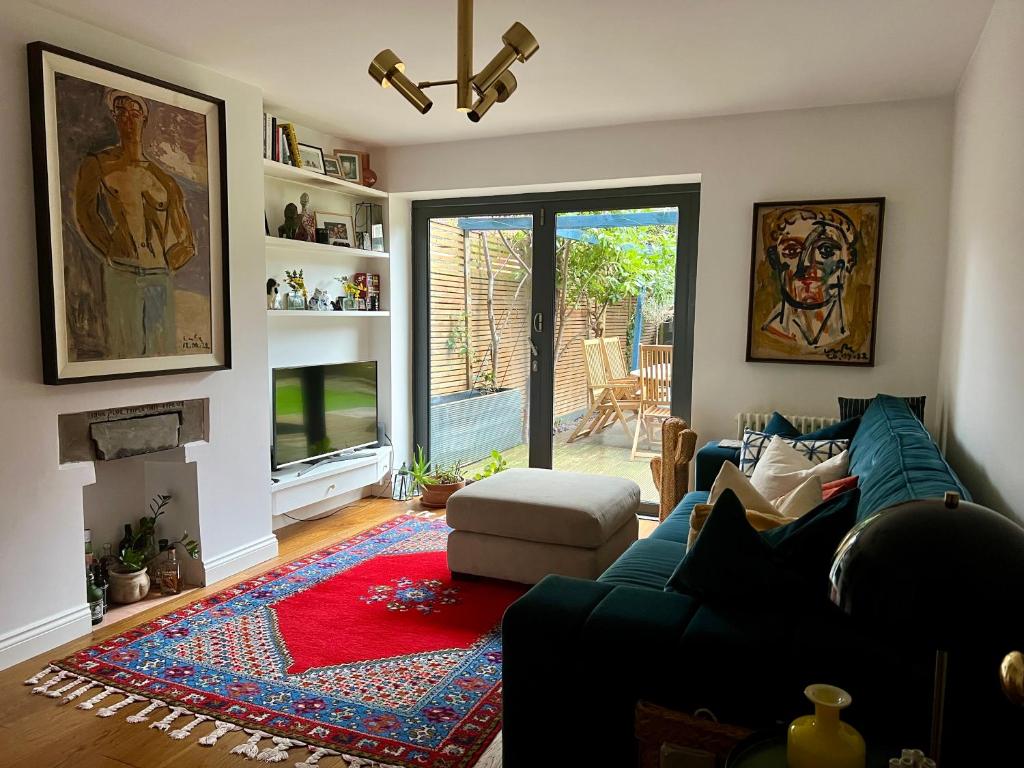 伦敦Urban Oasis Chic 1BR Flat with Spacious Garden的带沙发和壁炉的客厅
