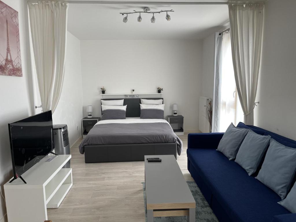 戈内斯HOUSE COSY ONE的一间卧室配有一张床和一张蓝色的沙发