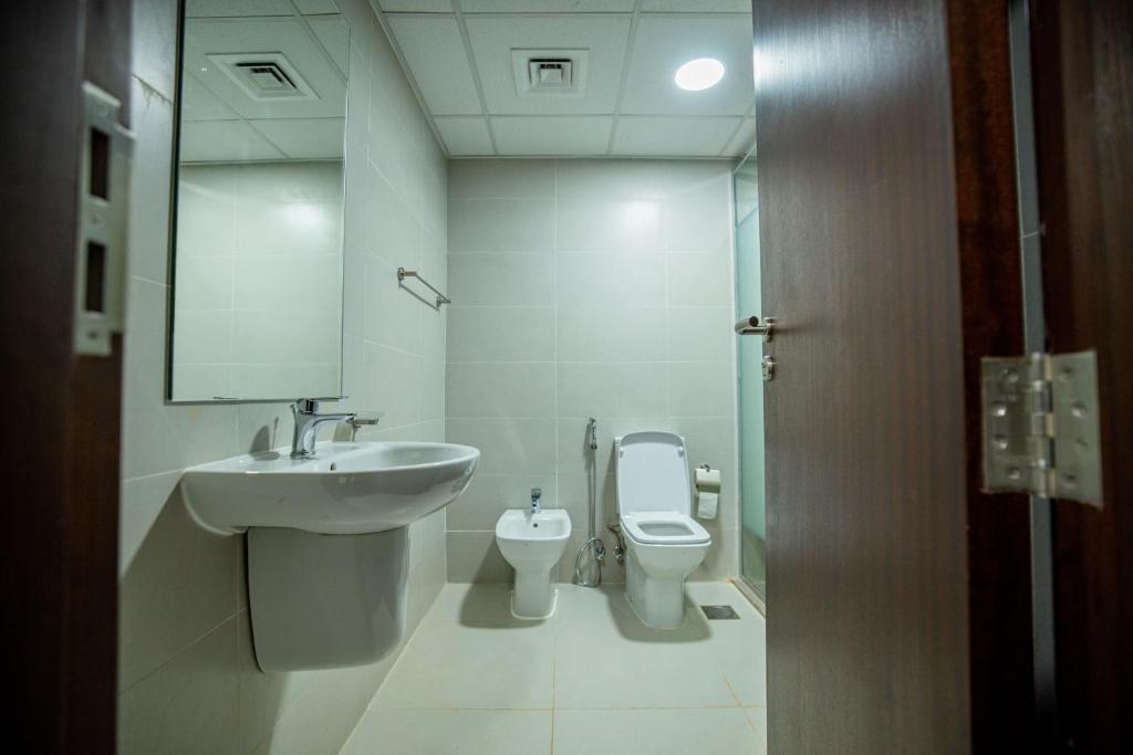 尼亚美Niamey Mall & Residence的一间带水槽、卫生间和镜子的浴室