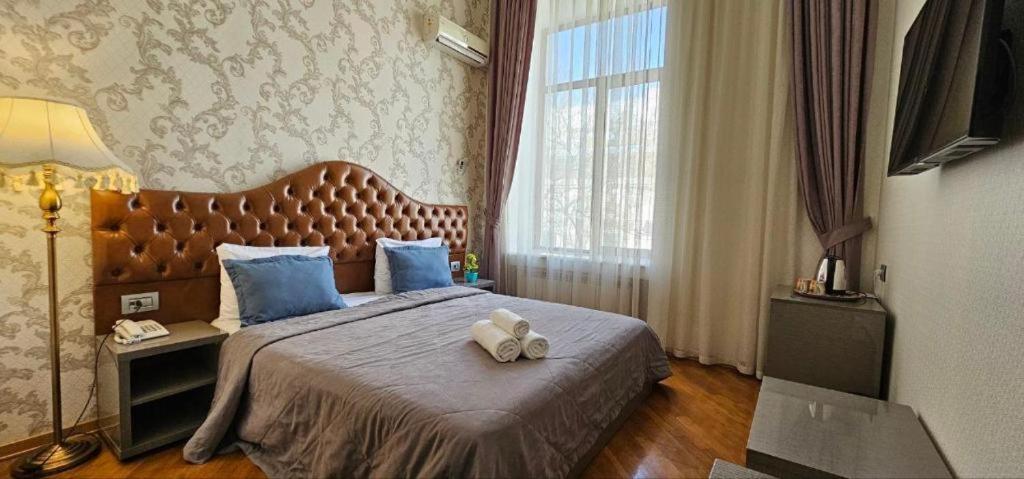 巴库Pilot Baku hotel的一间卧室配有一张带蓝色枕头的大床
