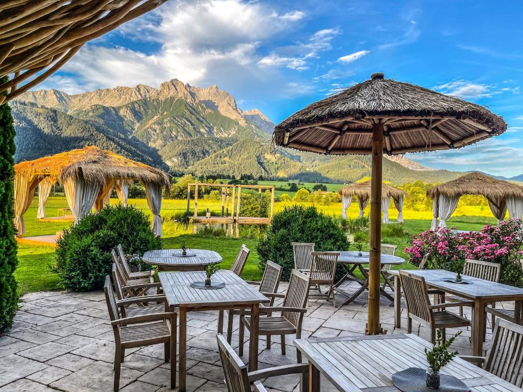 萨菲登安斯泰内嫩米尔萨利特霍夫酒店的庭院配有桌椅,背景为山脉