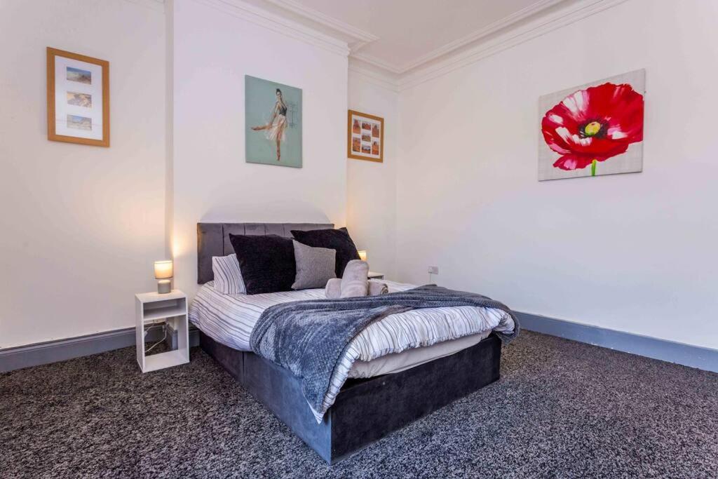 桑德兰Guest Homes - Bambro Flat的卧室配有一张挂着红花的床。