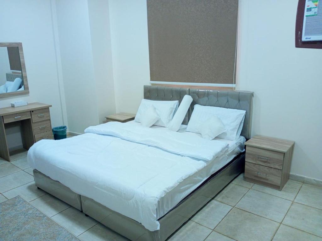 麦地那شقق الفتح الخاصة Al-Fateh Private Apartments的卧室内的一张带白色床单和枕头的床