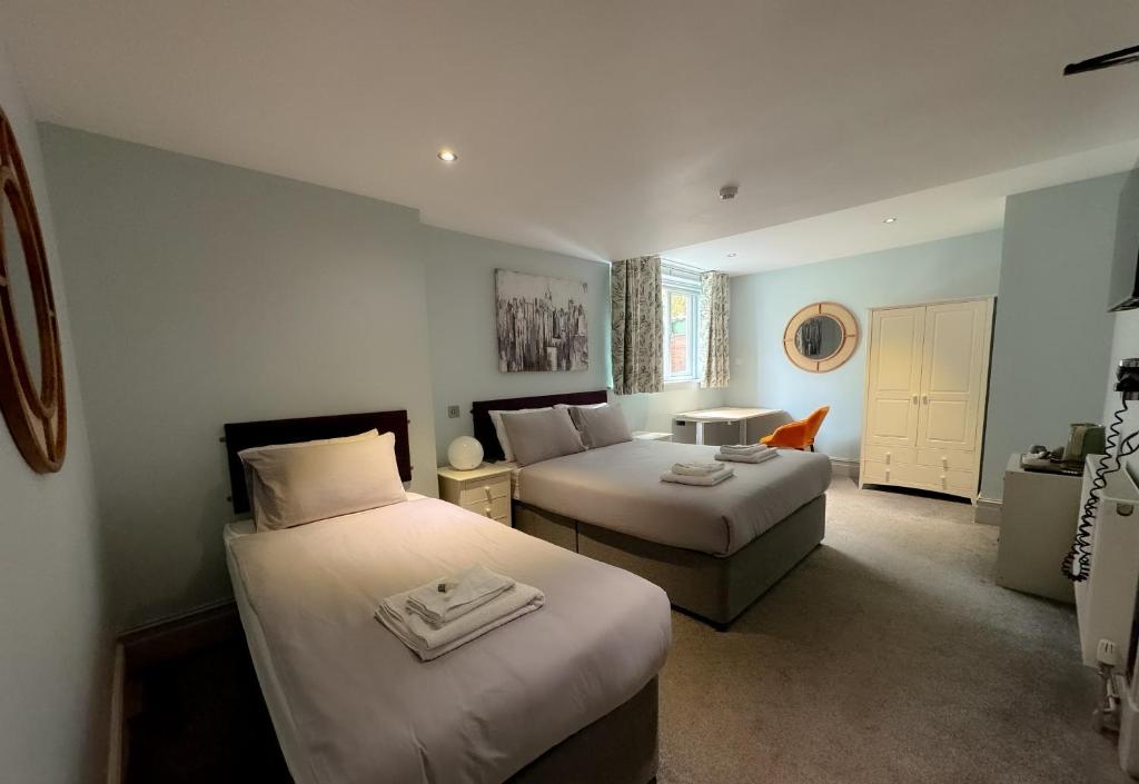 班戈Nomi Rooms & Restaurant的酒店客房,设有两张床和一张沙发