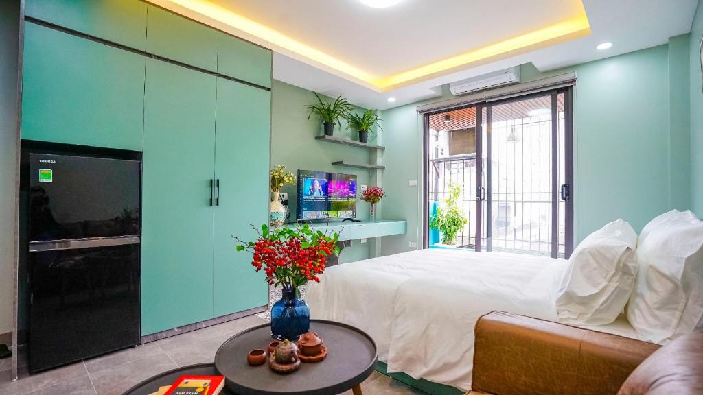 河内Hanoi Ben's Apartment and Hotel的一间设有床铺和鲜花桌的房间