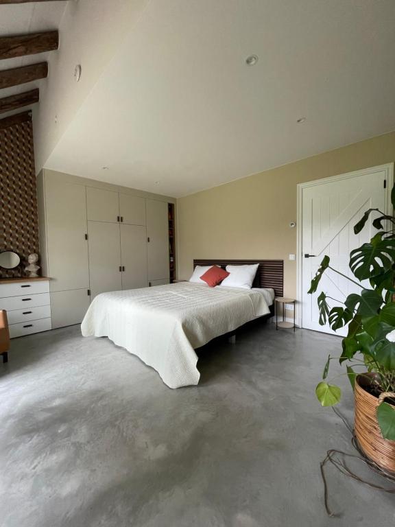 AnderenDe Loeghoeve的卧室配有白色大床和植物
