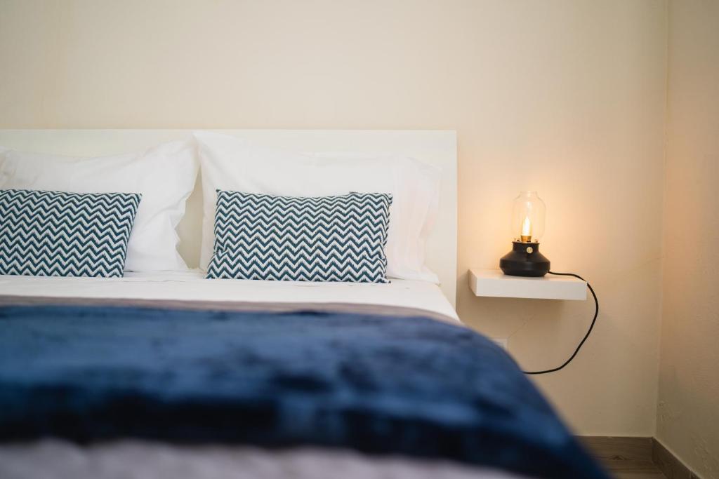 圣罗克杜皮库Casas do Navalhão的一张带蓝色和白色枕头的床和一盏灯