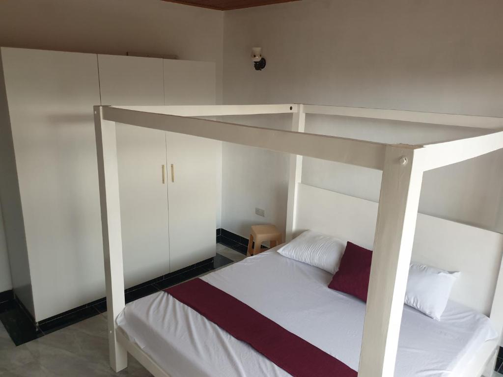 马林迪RAKA HOLIDAY HOMES的卧室配有一张白色的床和一张高架床