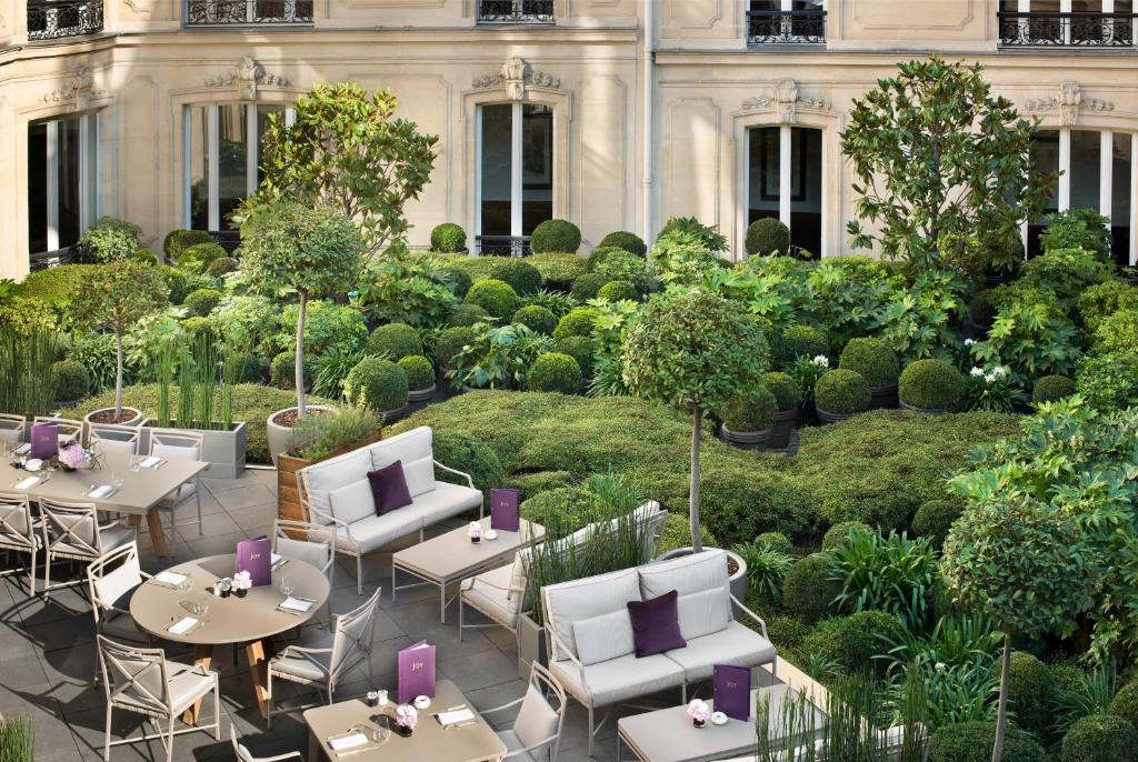 巴黎Hôtel Barrière Fouquet's Paris的大楼前带桌椅的天井